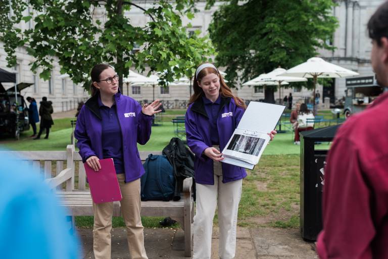 Two tour guides delivering material to the MyAV Walking Tour attendees