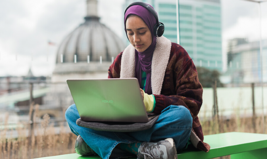 A student works on a laptop on the roof terrace of the MyAV students centre.